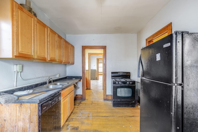 kitchen featuring sink, black appliances, and light wood-type flooring