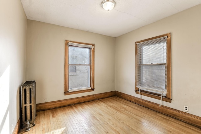 empty room featuring light hardwood / wood-style floors and radiator heating unit