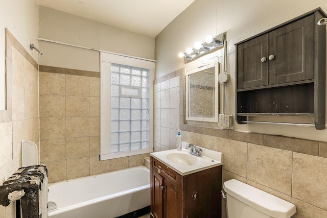 bathroom with toilet, tile walls, and a tub