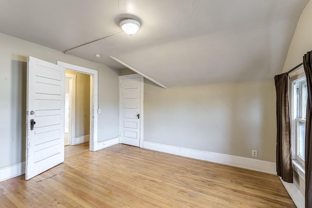 bonus room featuring light wood-type flooring and vaulted ceiling