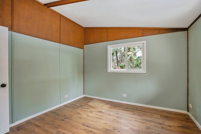 empty room with light hardwood / wood-style floors and lofted ceiling