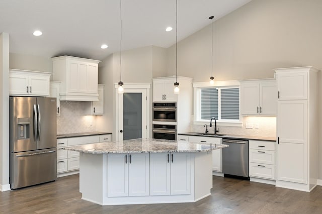 kitchen featuring sink, hanging light fixtures, stainless steel appliances, high vaulted ceiling, and a kitchen island