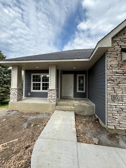 8001 Petunia St, Victoria, MN 55386 - property entrance featuring stone siding and covered porch