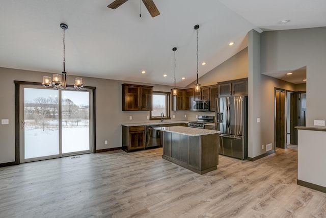 kitchen with pendant lighting, light hardwood / wood-style flooring, dark brown cabinets, a kitchen island, and stainless steel appliances