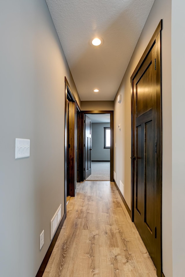 corridor with light hardwood / wood-style floors