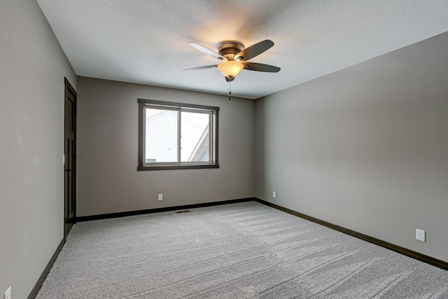 empty room featuring a textured ceiling, ceiling fan, and light carpet