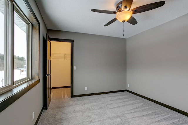 carpeted spare room with ceiling fan