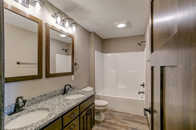 full bathroom with shower / bathing tub combination, vanity, toilet, a textured ceiling, and wood-type flooring