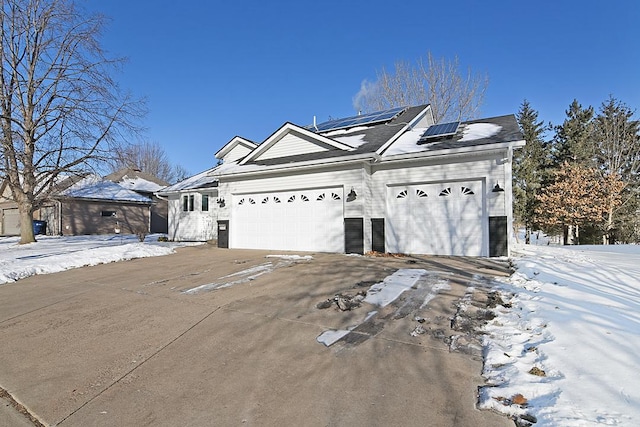 view of front of house featuring a garage and solar panels