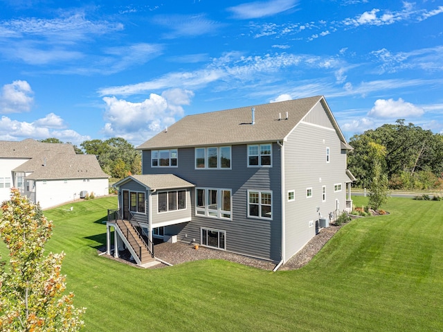 rear view of property featuring cooling unit, a yard, and a sunroom