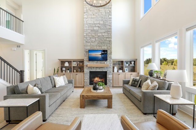 living room featuring a high ceiling, an inviting chandelier, and a fireplace