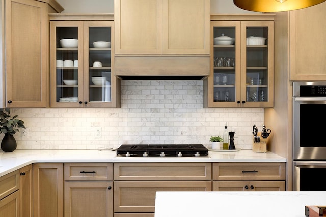 kitchen featuring backsplash, light brown cabinets, stainless steel appliances, and custom range hood