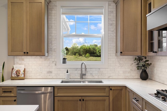 kitchen featuring decorative backsplash, sink, appliances with stainless steel finishes, and light stone countertops