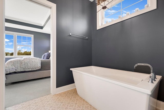 bathroom with ornamental molding and a tub to relax in