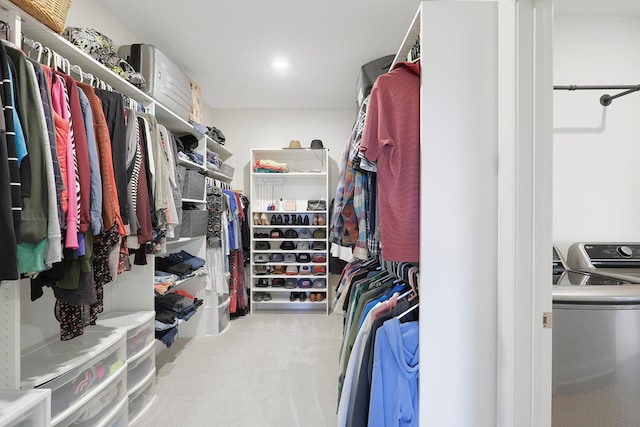 spacious closet featuring washer and dryer and light colored carpet