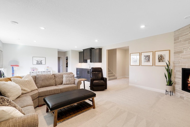 living room with sink, light carpet, and a fireplace