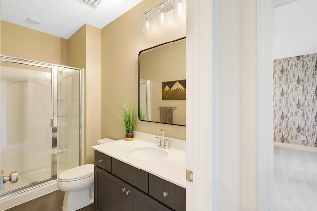 bathroom featuring toilet, vanity, and an enclosed shower