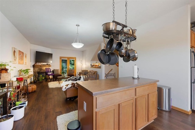 kitchen featuring a center island, light brown cabinets, dark wood-type flooring, and pendant lighting