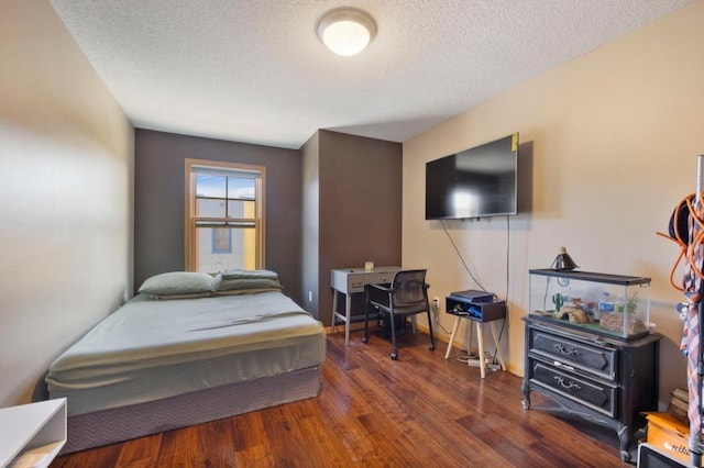 bedroom featuring a textured ceiling and dark hardwood / wood-style floors