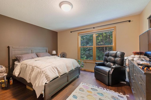 bedroom with a textured ceiling and dark hardwood / wood-style floors