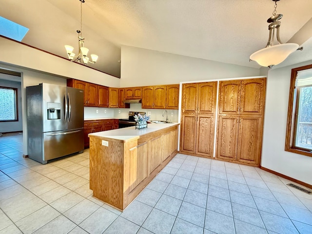 kitchen featuring stainless steel refrigerator with ice dispenser, a skylight, pendant lighting, a notable chandelier, and black electric range