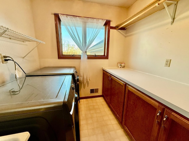 washroom featuring cabinets and washing machine and dryer