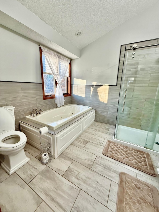 bathroom featuring a textured ceiling, independent shower and bath, tile walls, and toilet