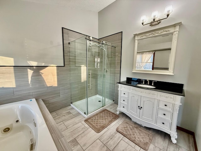 bathroom featuring tile patterned flooring, vanity, separate shower and tub, and a textured ceiling