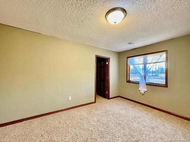 carpeted spare room featuring a textured ceiling