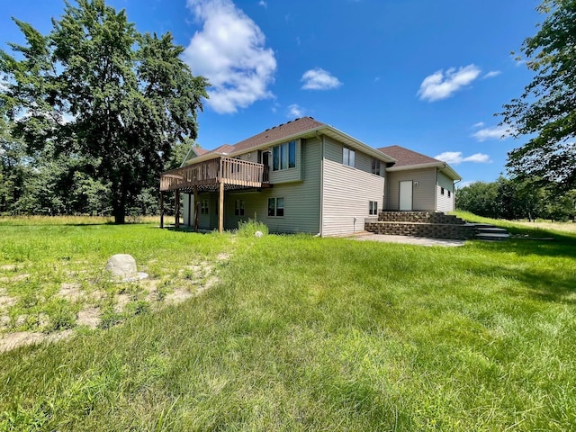 back of property featuring a deck and a lawn