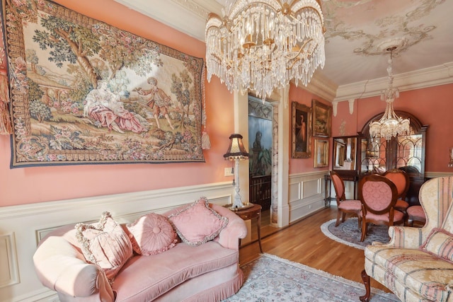 sitting room featuring a chandelier, ornamental molding, and hardwood / wood-style flooring