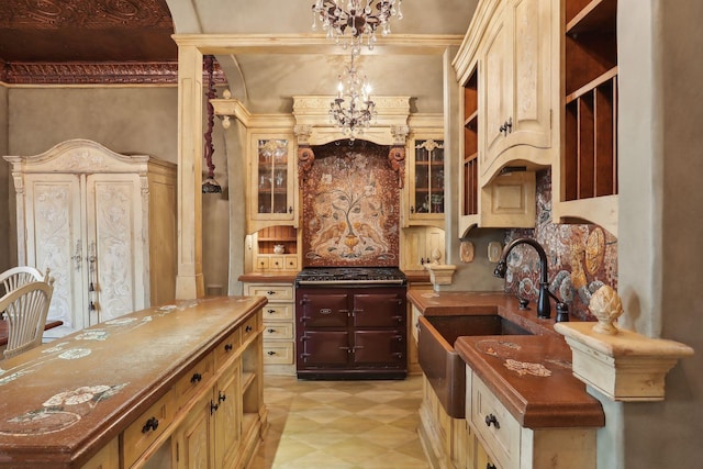 kitchen featuring french doors, sink, crown molding, a chandelier, and decorative light fixtures