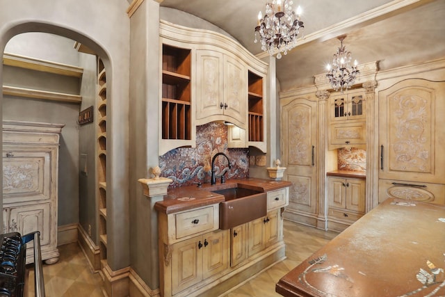 kitchen featuring sink, wood counters, a notable chandelier, decorative light fixtures, and decorative backsplash