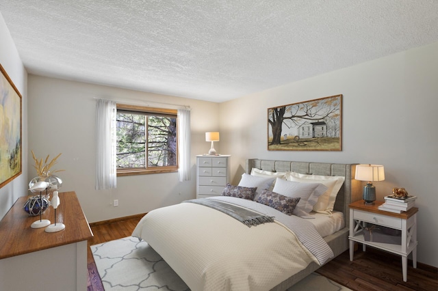 bedroom with baseboards, a textured ceiling, and wood finished floors