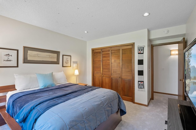 bedroom featuring a closet, light carpet, baseboards, recessed lighting, and a textured ceiling