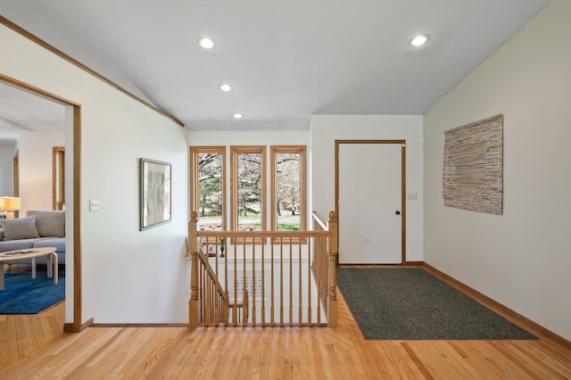 foyer with baseboards, recessed lighting, wood finished floors, and vaulted ceiling