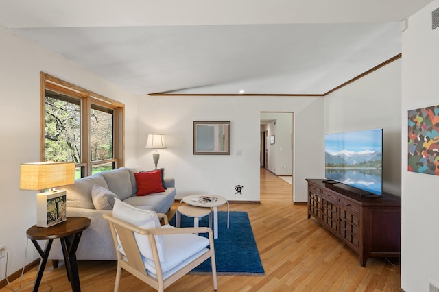 living area with light wood-style floors, baseboards, vaulted ceiling, and visible vents