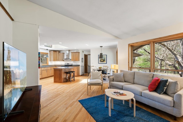 living room featuring recessed lighting, light wood finished floors, lofted ceiling, and a healthy amount of sunlight