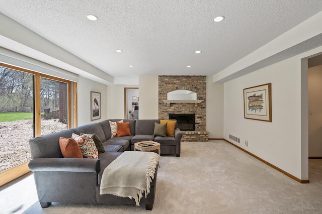 living area with a textured ceiling, visible vents, a fireplace, baseboards, and light carpet