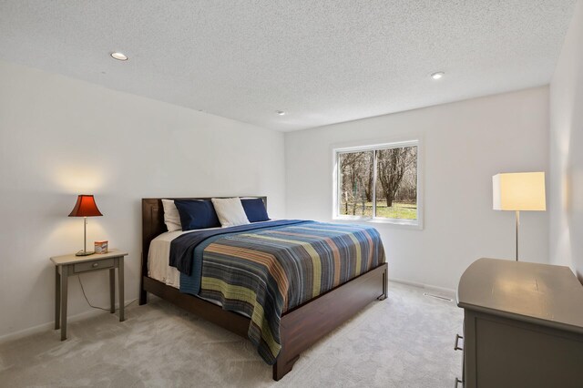 bedroom featuring recessed lighting, a textured ceiling, light colored carpet, and baseboards