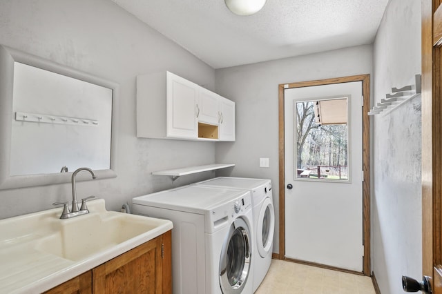 clothes washing area featuring washing machine and clothes dryer, baseboards, a sink, and cabinet space