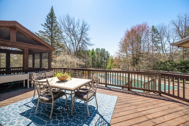 wooden terrace featuring a fenced in pool and outdoor dining area