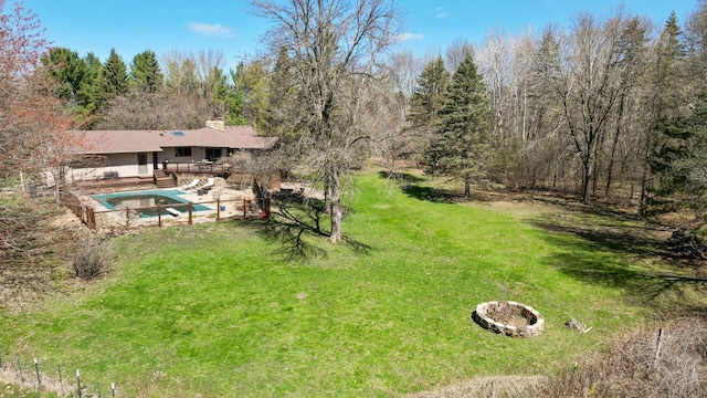 view of yard featuring a fire pit, a covered pool, and a wooden deck