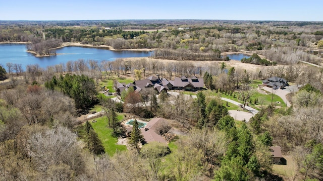 birds eye view of property with a water view and a wooded view