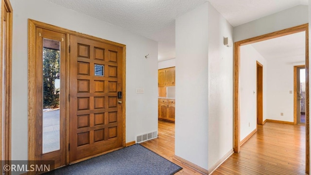 entrance foyer featuring light hardwood / wood-style flooring and a textured ceiling