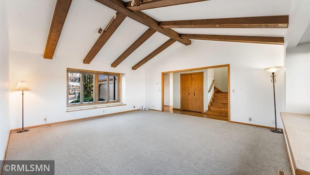 unfurnished living room with beam ceiling, carpet, and high vaulted ceiling