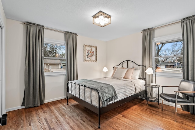 bedroom with wood finished floors and baseboards