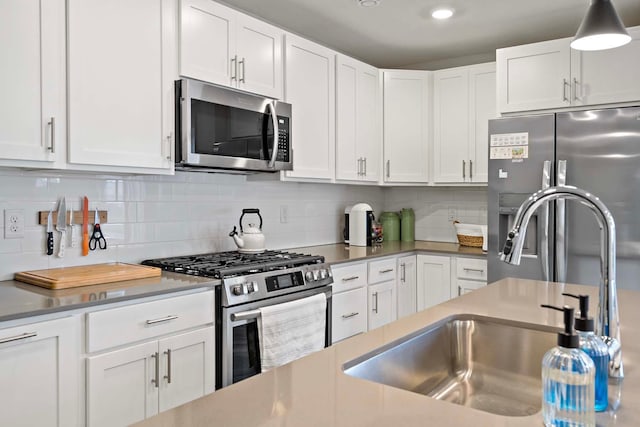 kitchen featuring decorative backsplash, sink, white cabinets, and stainless steel appliances