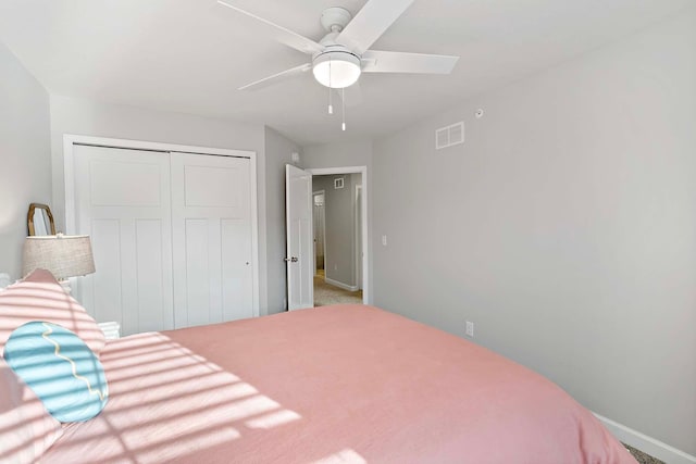 carpeted bedroom with a closet and ceiling fan