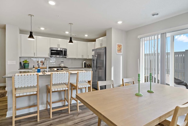 dining space with sink and light hardwood / wood-style floors